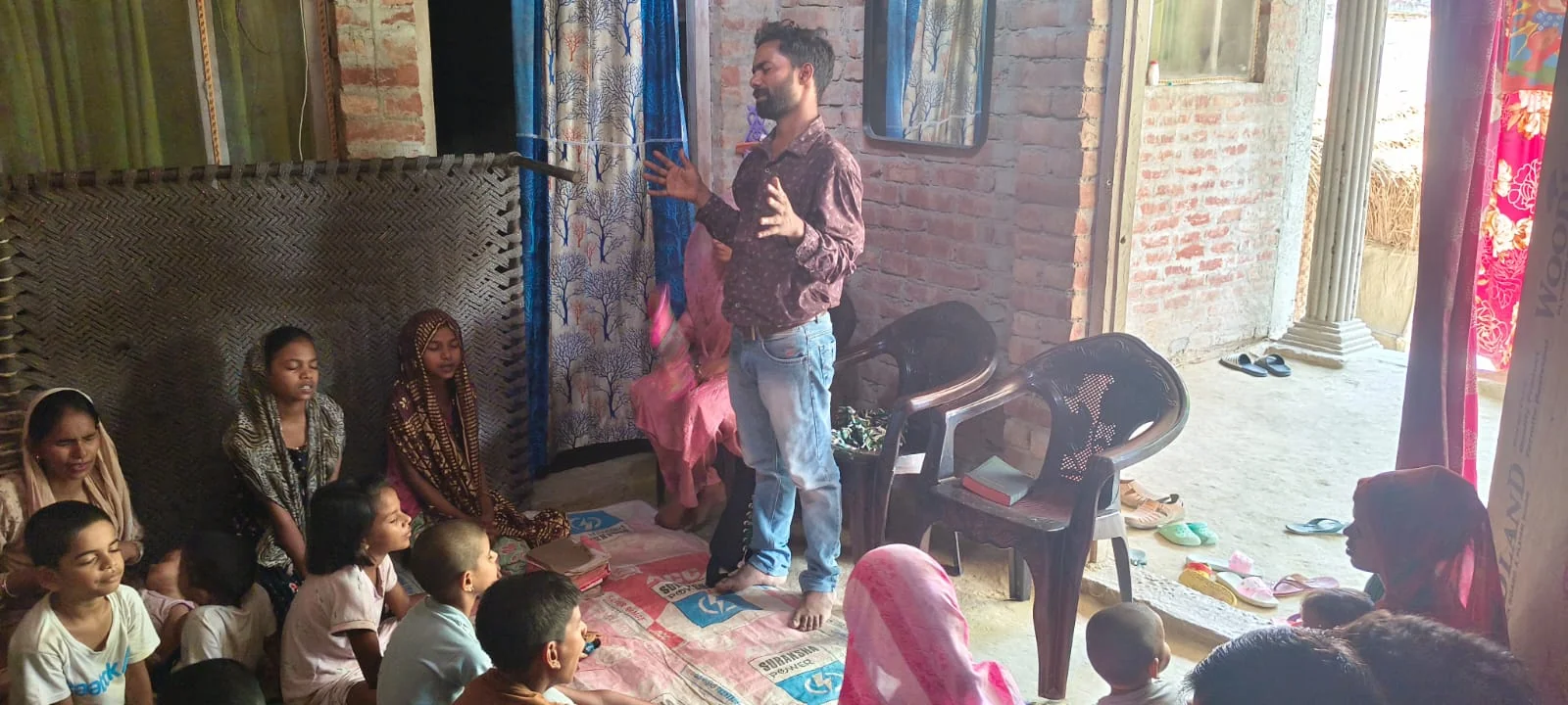 A young preacher sharing the Gospel in a village house church in North India